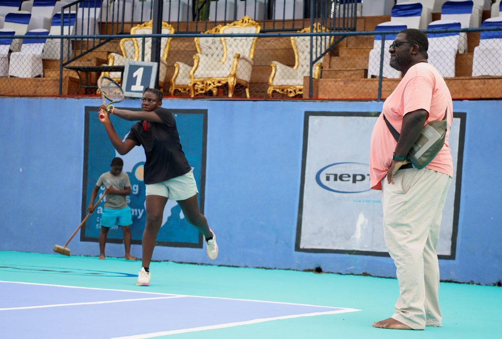 Joseph Oyebog coaching a young tennis player